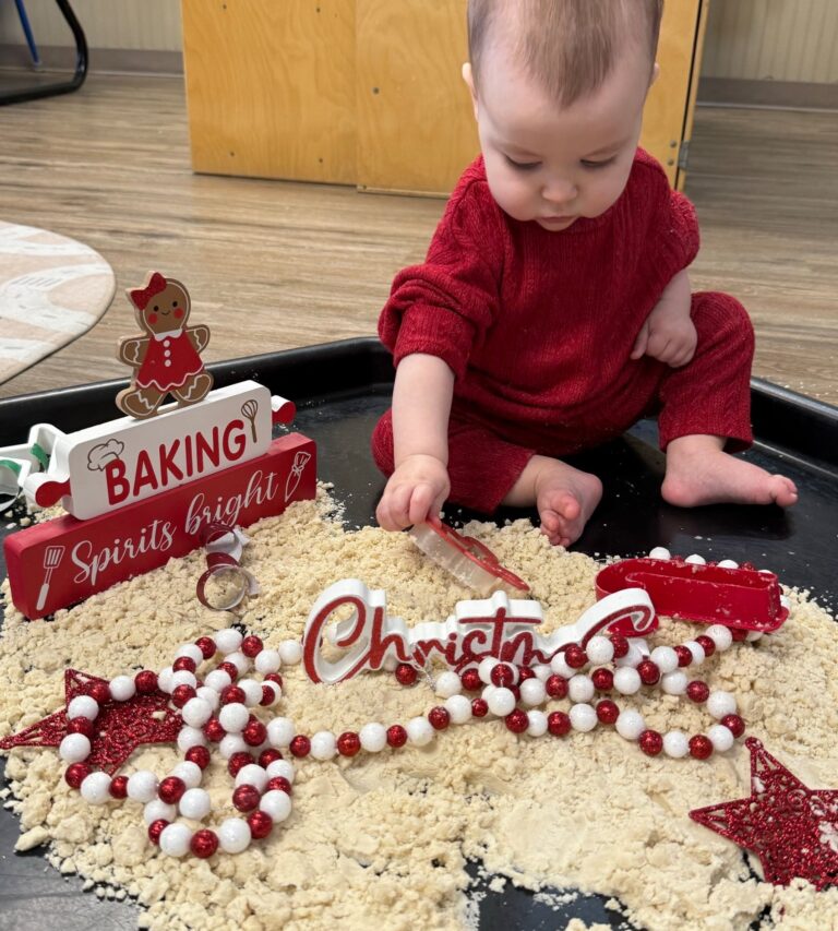 Infant exploring a holiday sensory bin