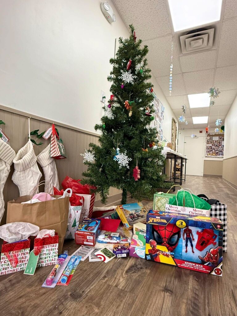 Donated holiday gifts for a foster family under the tree