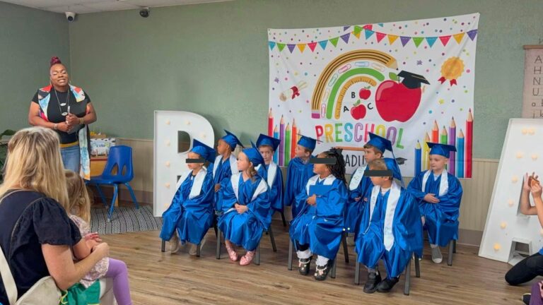 Pre-K graduates in blue caps and gowns at Rise Above Early Learning Center
