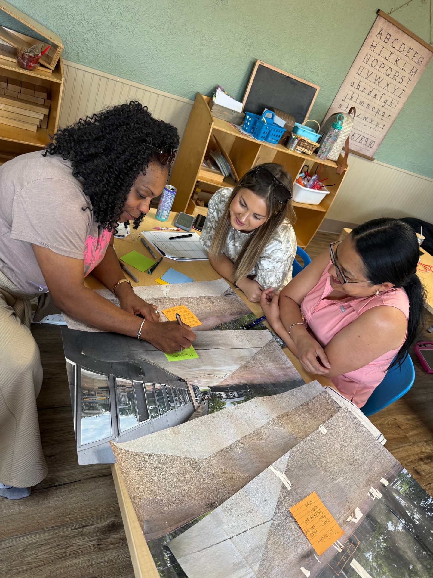 Teachers add notes to a shared classroom plan during a professional development activity.