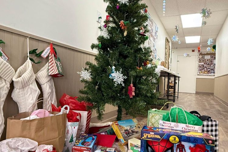 Donated holiday gifts for a foster family under the tree