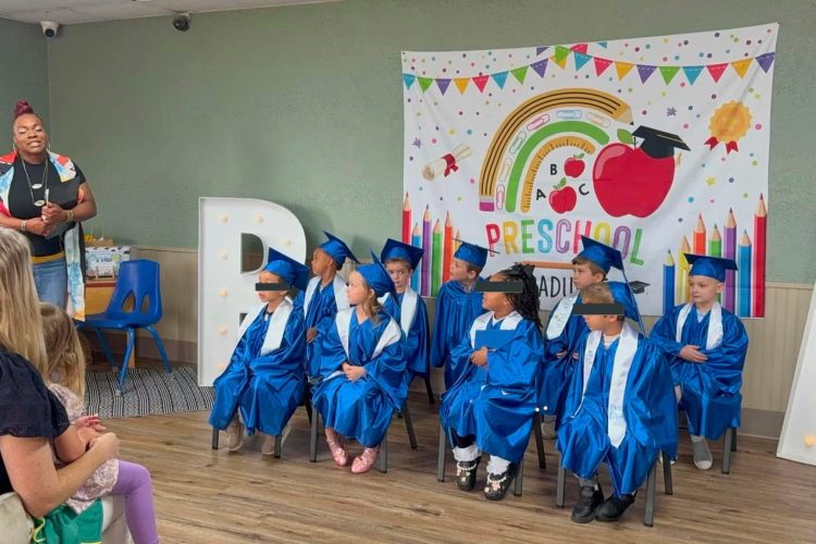 Pre-K graduates in blue caps and gowns at Rise Above Early Learning Center